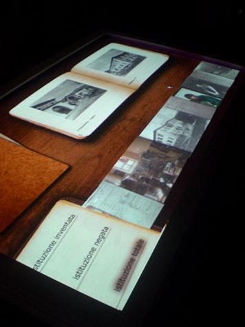 Tavolo di legno con documenti interattivi dell'ex manicomio di Trieste