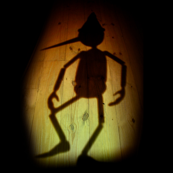 Ombra del burattino Pinocchio su un pavimento di legno