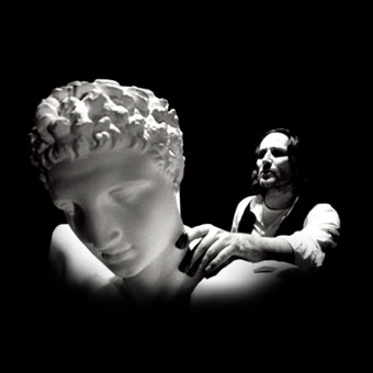 Moni Ovadia con una statua classica in una scena di "Delfi (studio per suono, voce, video e buio)"